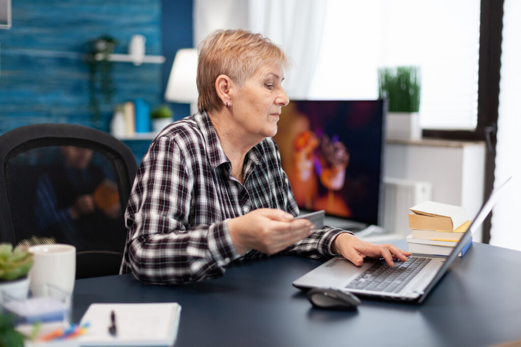 Positive senior woman paying bills