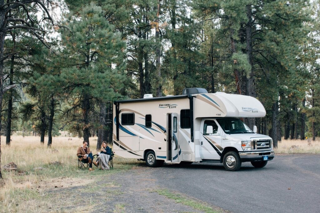 Couple sitting outside their camping van