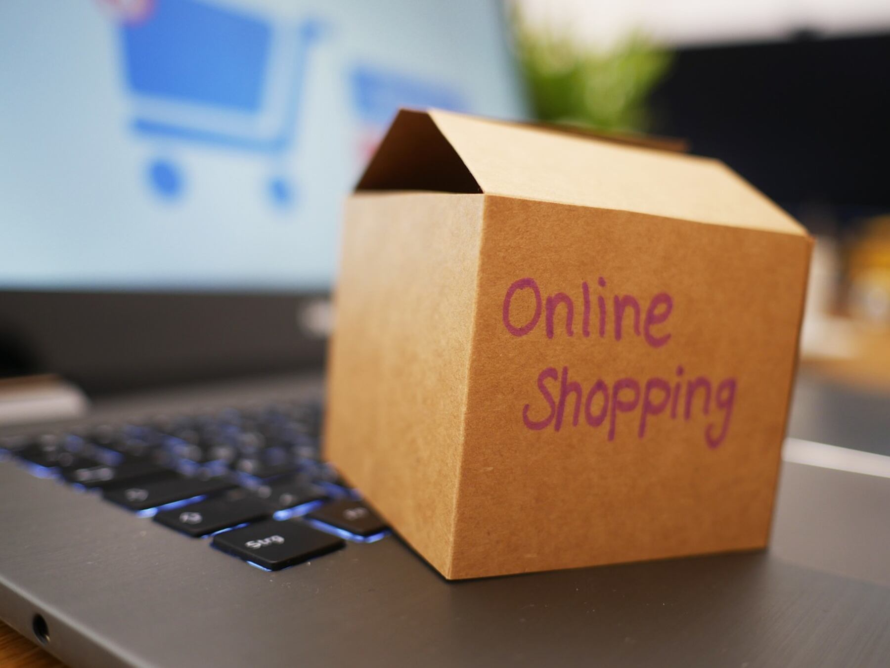 A small box with a note "online shopping" placed on a the laptop
