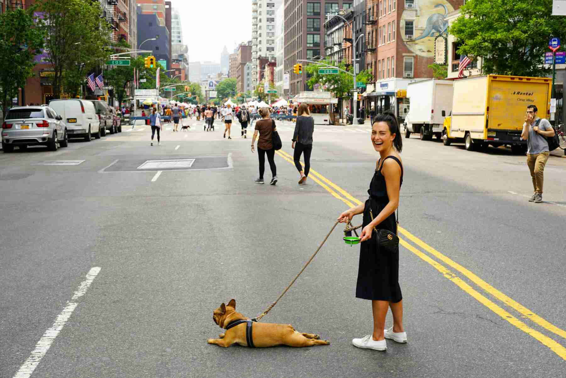 A woman walking his dog on the streets