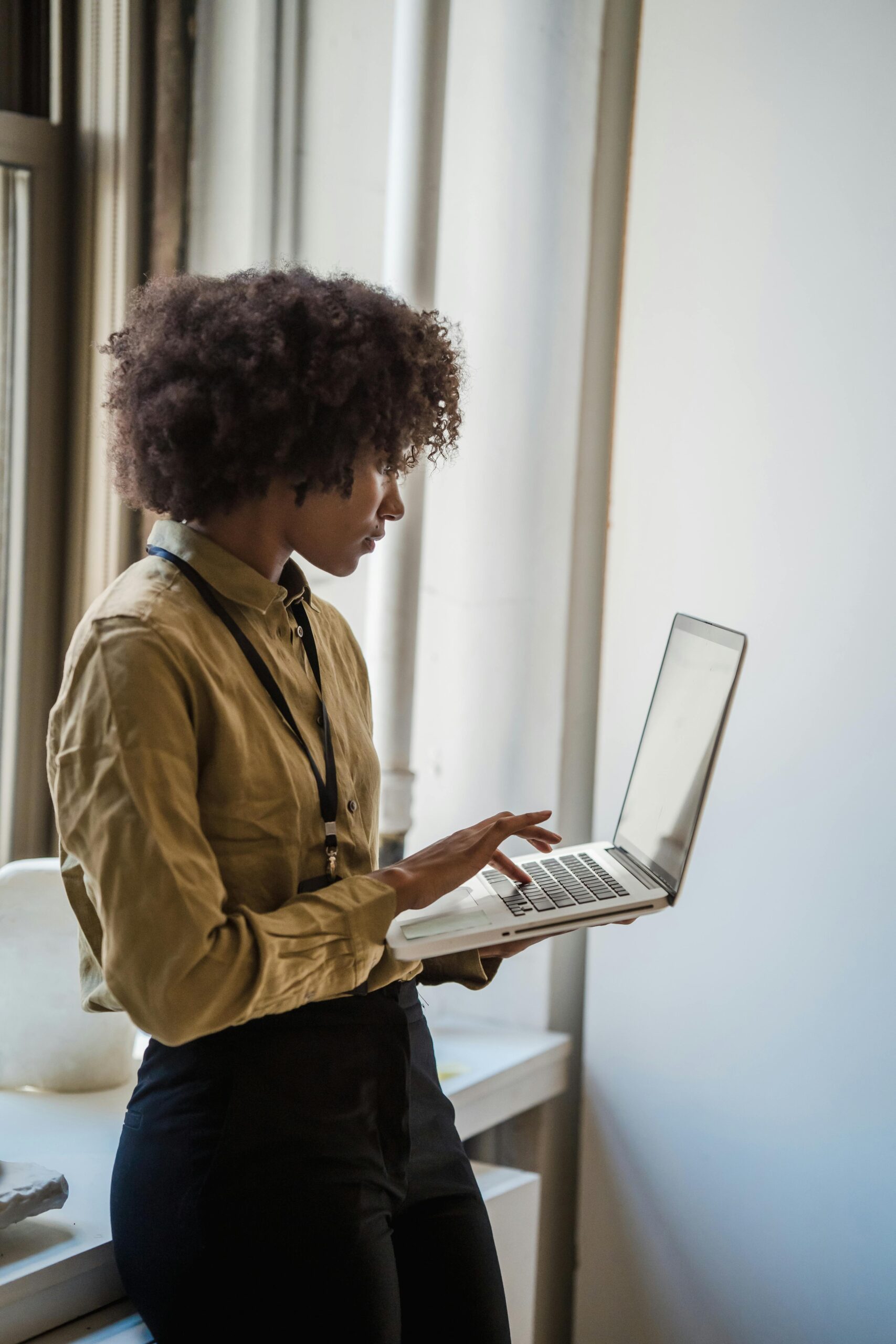 A woman using her laptop while standing
