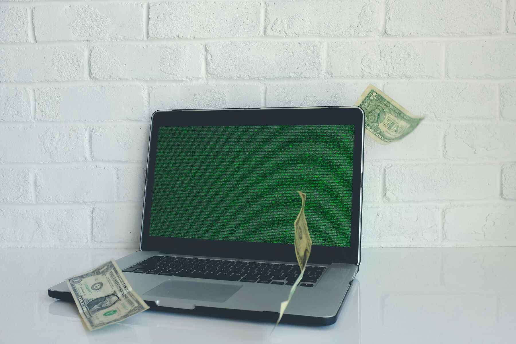 Money bills falling on the laptop