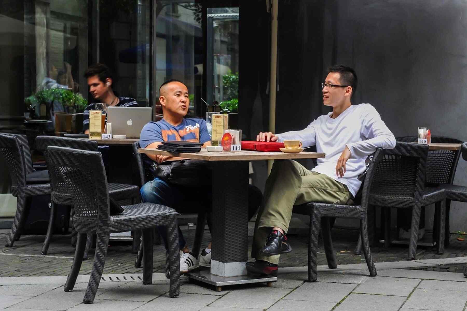 Two men outside a restaurant talking