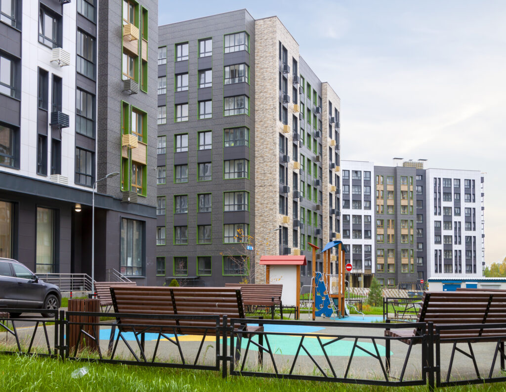 A multifamily building with a pool and park benches.