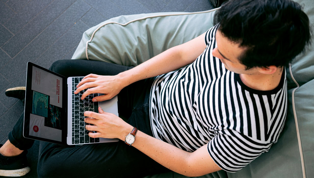 man in striped black and white shirt using laptop