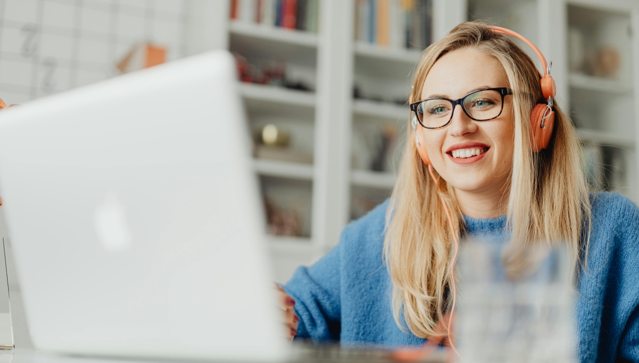 girl in blue shirt using laptop at desk