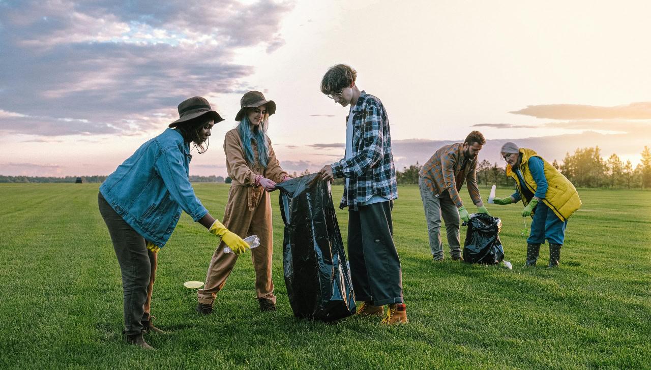 volunteers picking up trash in a field